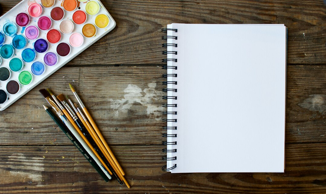 Open notebook and pen on a wooden office desk